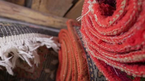 Close-Up of Hand-Woven Persian Carpets Stacked in Traditional Rug Shop Stock Footage 335645285