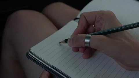 Close-up of a hand writing a 2026 personal goals list with a pencil in... Stock Footage 323129077