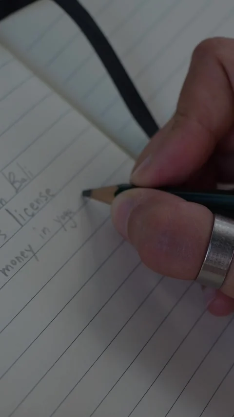 Close-up of a hand writing a 2026 personal goals list with a pencil... Stock Footage 344455031