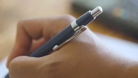 Close up of hand writing, calculator in background Video stock 94015454
