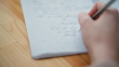 Close-up hand writing in cursive on wooden table Stock Footage 302268363