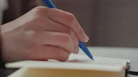 Close up Hand Writing in Notebook with Blue Pen on Soft Lighting Indoor Surface 스톡 동영상 347101784