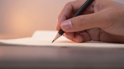 Close-up of hand writing on a notebook with pencil Stock Footage 137216464