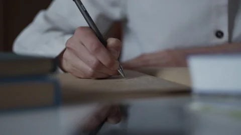 Close up hand writing notes in personal diary, studies in library with books Stock-Footage 152587204
