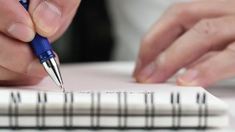 Close up hand writing paper on notebook with blue pen Video stock 201316383
