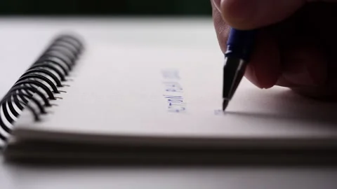 Close up hand writing paper on notebook with blue pen Video stock 201316452