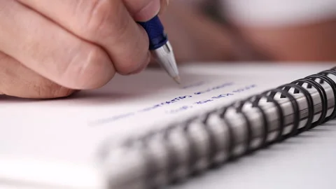 Close up hand writing paper on notebook with blue pen Video stock 201316488