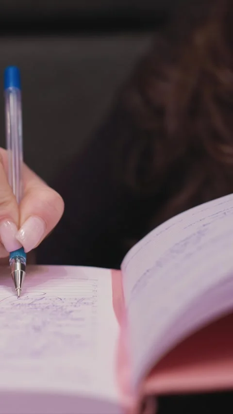 Close up Hand Writing with Pen on Lined Notebook with stationery paper purple Stock Footage 348162525