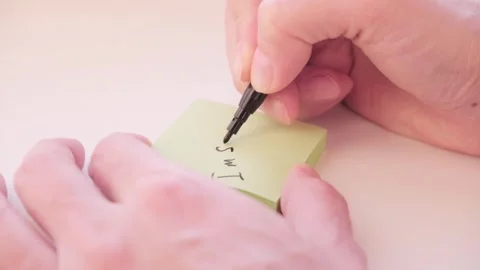 Close-up of hand writing the phrase "I am sorry" with a black marker on a block Stock Footage 335116714