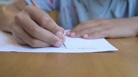 Close-up of hand writing with a sharpened pencil on white paper. Concept of Stock Footage 316090199