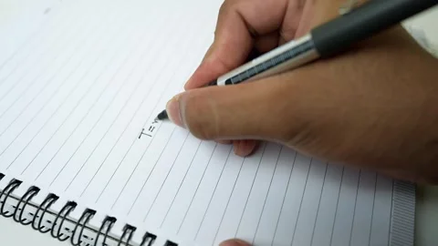 Close-up of a hand writing in a spiral notebook with a pen Stock Footage 318057200