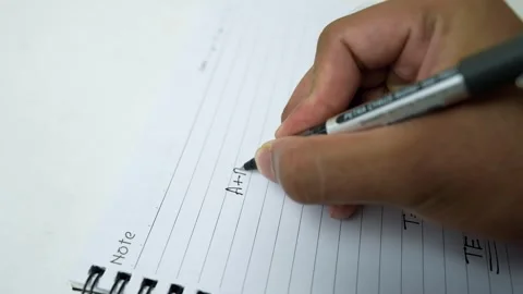 Close-up of a hand writing in a spiral notebook with a pen Stock Footage 318057207