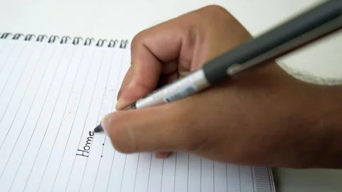 Close-up of a hand writing in a spiral notebook with a pen Stock Footage 320726234