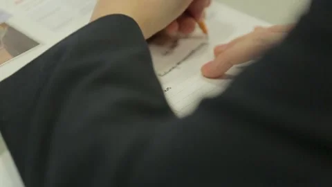 Close-Up of Hand Writing in Workbook in Classroom Stock Footage 296845960
