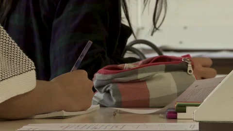 Close-Up of Hand Writing in Workbook in Classroom Stock Footage 296846052