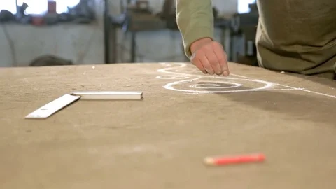 Close-up hand of a young blacksmith who draws a chalk sketch on the table Stock Footage 76391561
