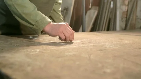 Close-up hand of a young blacksmith who draws a chalk sketch on the table Stock Footage 76411146