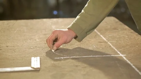 Close-up hand of a young blacksmith who draws a chalk sketch on the table Stock Footage 77003495