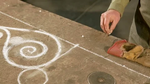 Close-up hand of a young blacksmith who draws a chalk sketch on the table Stock Footage 77003698