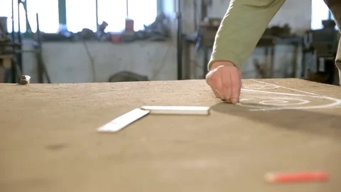 Close-up hand of a young blacksmith who draws a chalk sketch on the table Stock Footage 77003959