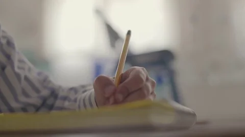 CLOSE-UP. Hand of young boy do Homework. Dolly Shot Stock Footage 76926543