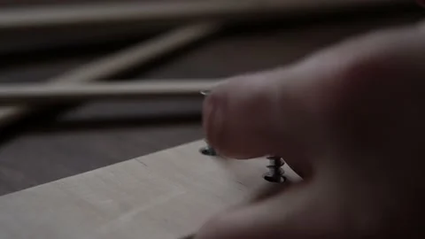 Close Up Hand Young Man Drives Screws Lays Out Parts Of Bookcase On Floor For Stock Footage 169717108
