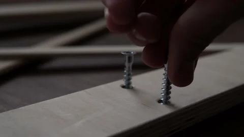 Close Up Hand Young Man Drives Screws Lays Out Parts Of Bookcase On Floor For Stock Footage 169718360