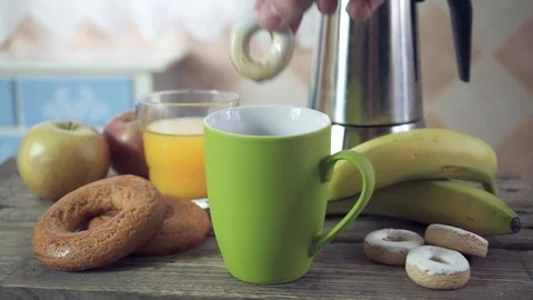 Close up of a hand from a young man dunks a donut in coffee Stock Footage 102098748