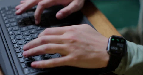Close up hand young man using laptop typing working in cafe using smart watch Stock Footage 197591735