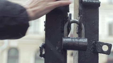 Close up hand of young man who standing and waiting near iron gates under rain Video stock 69038667