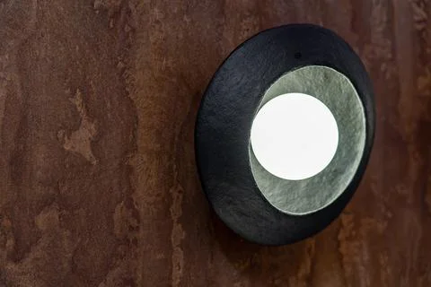 Close up of handcrafted black ceramic wall lamp Фото