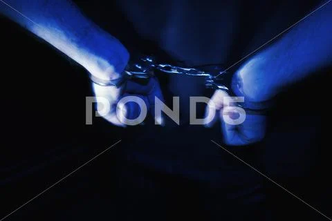 Close up of handcuffs on man wrist Stock Photos