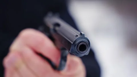 Close-up of handgun being pointed at camera, creating tension and dramatic focus Stock Footage 299234824