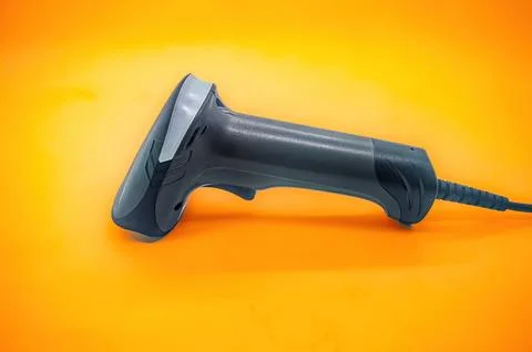 A close up of a handheld barcode scanner on an orange background, showcasin.. Stock Photos