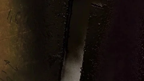 Close up handheld footage of a dark coated metal component with textured Stock Footage 332919627