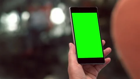 Close up on a handheld mobile phone with blank green screen Video stock 158927678