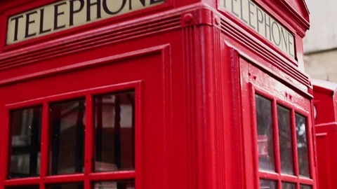 Close-up handheld panning shot of red telephone phone booth in city Stock Footage 114841773
