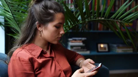 Close-up handheld shot of beautiful young woman using smartphone in slow motion Vídeo Stock 114883486
