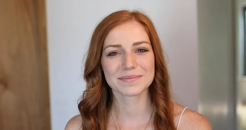 Close-up handheld shot of beautiful young woman smiling at camera Stock Footage 119792844