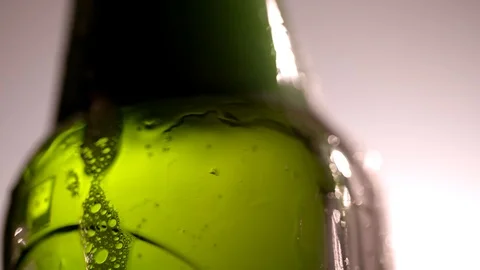 Close up handheld shot of beer bubbles in a green bottle Stock Footage 87857319