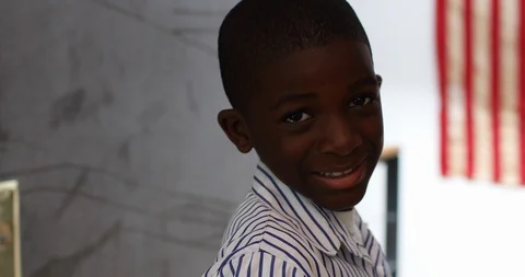 Close-up handheld shot of boy smiling and doing various expression Stock Footage 119756154