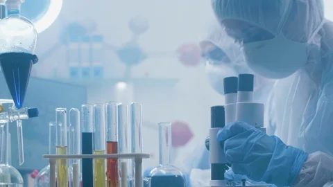 Close up handheld shot of chemists working in a laboratory filled with fumes or Stock Footage 109399616