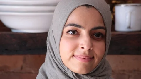 Close-up handheld shot of confident young woman wearing hijab in kitchen Stock Footage 114860138