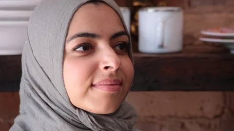 Close-up handheld shot of confident young woman wearing hijab in kitchen Stock Footage 114860145