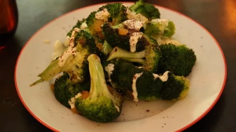 Close-up handheld shot of cooked broccoli placed on dining table Stock-Footage 114846644