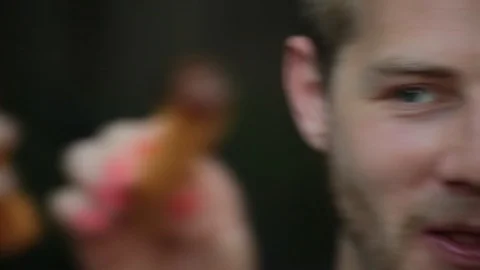 Close-up handheld shot of couples sitting and eating together churro in backyard Video stock 114862336