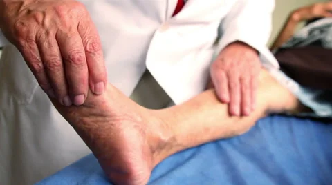 CLOSE UP-HANDHELD SHOT. Doctor's hands touching a patient leg during a check up. Stock Footage 48501884