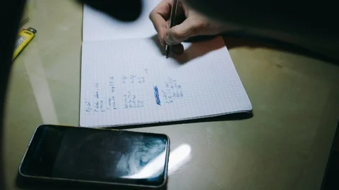 Close-up handheld shot of hands of boy doing math homework at desk Stock Footage 122513297