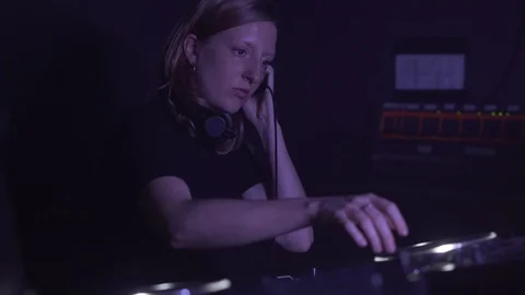 Close-up handheld shot of lady DJs working on control panel in club Stock Footage 114876975
