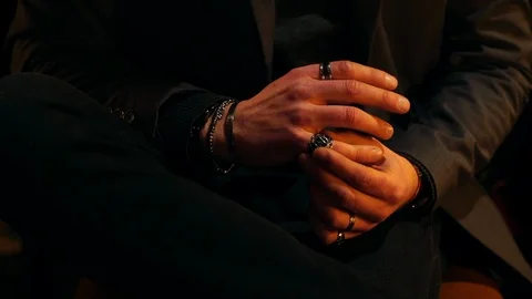 Close-up handheld shot of man adjusting ring on finger Stock Footage 120428613